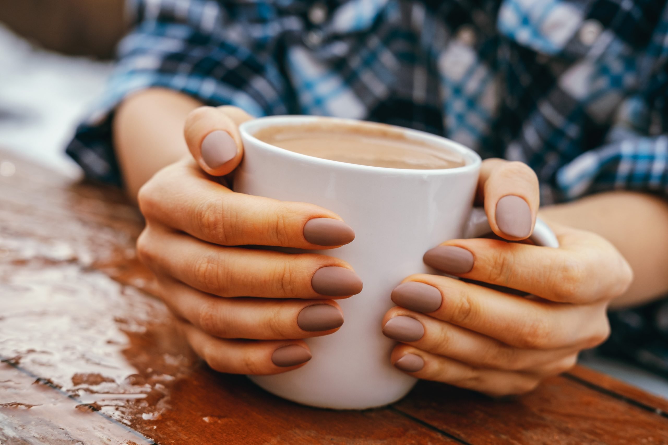 close up of woman's hands around a coffee cup