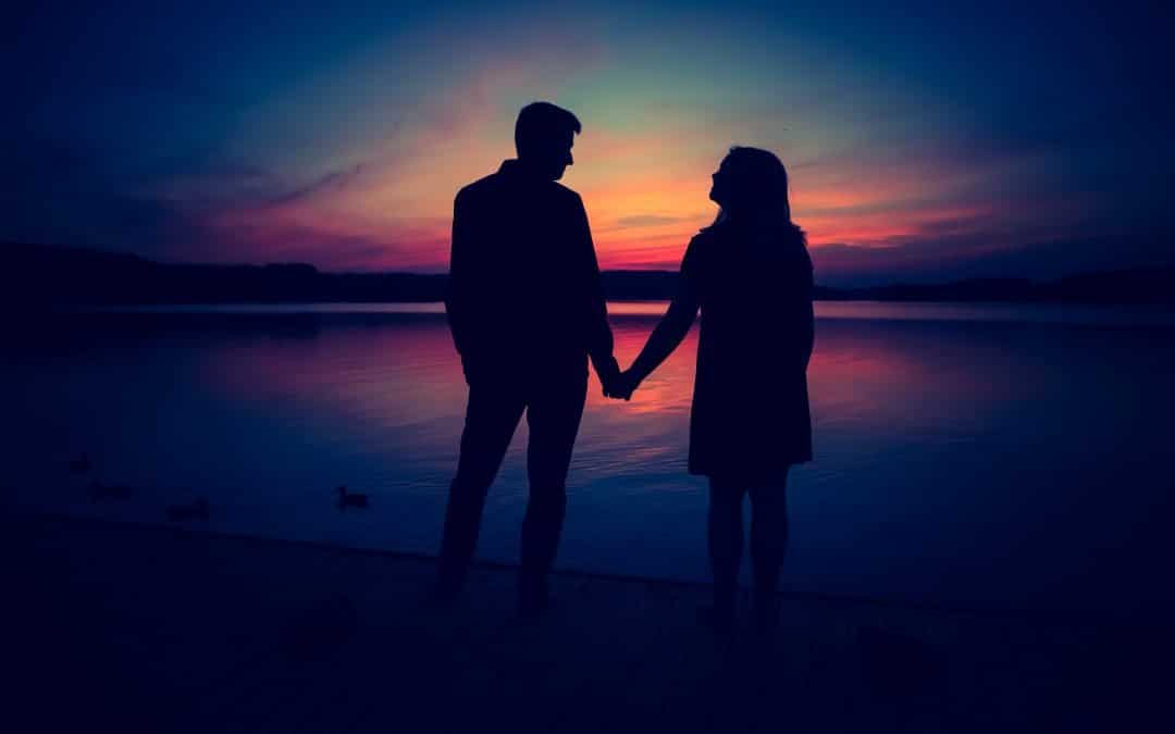 silhouette of a couple holding hands during a sun set