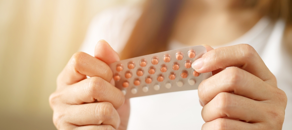 Close up of a woman's hand holding a pill packet